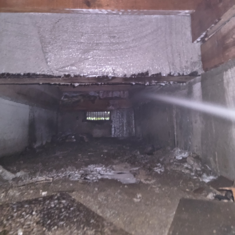 床下の基礎部分にシロアリ駆除剤を散布する様子