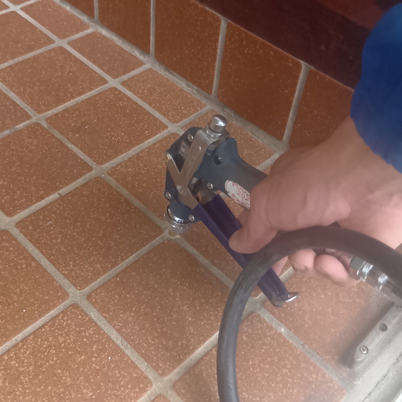 玄関の床にシロアリ駆除剤を注入する様子