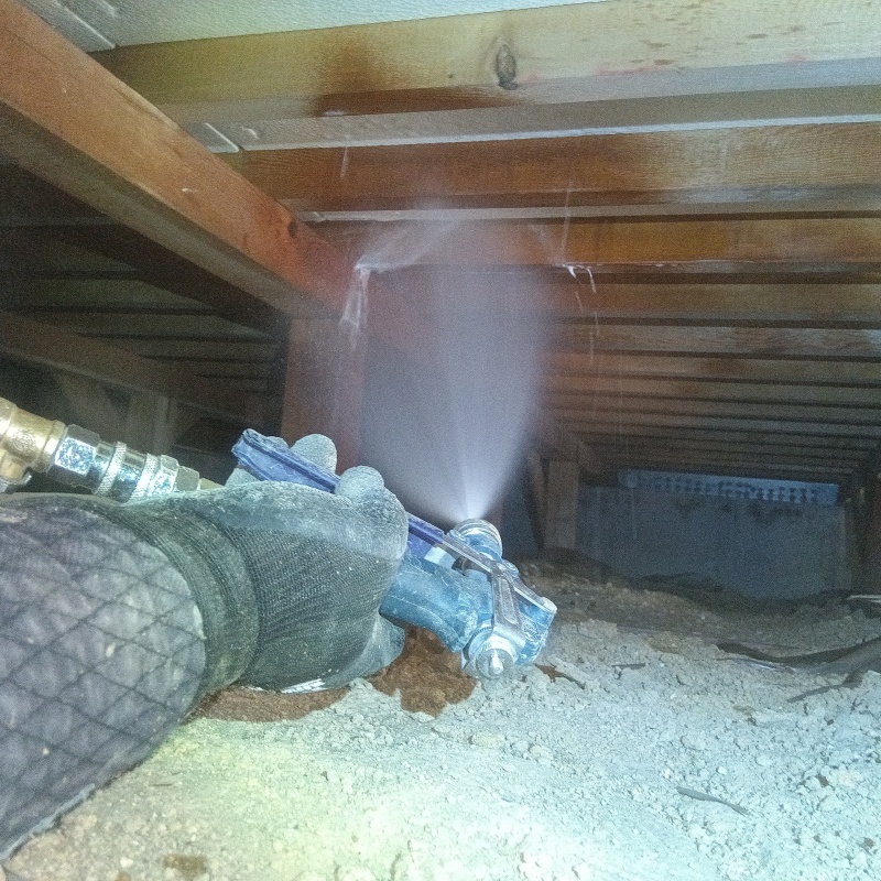 床下の木材にシロアリ駆除剤を散布する様子