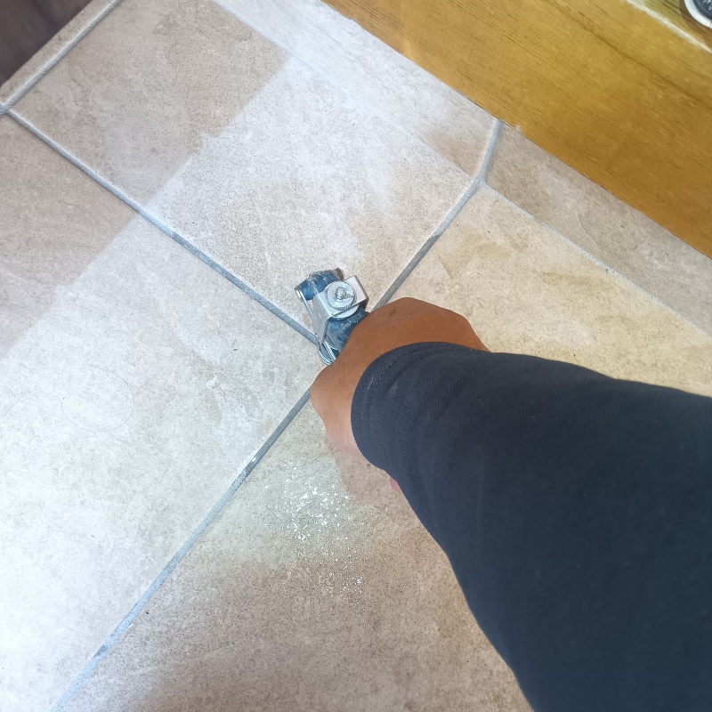 玄関の床にシロアリ駆除剤を注入する様子