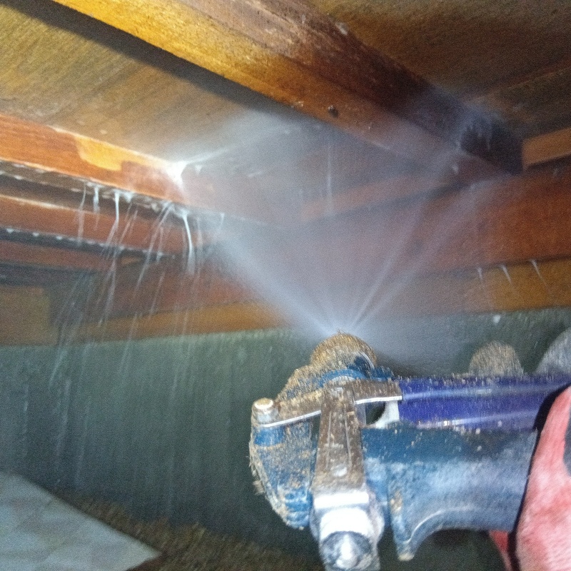 床下の木材にシロアリ駆除剤を散布する様子