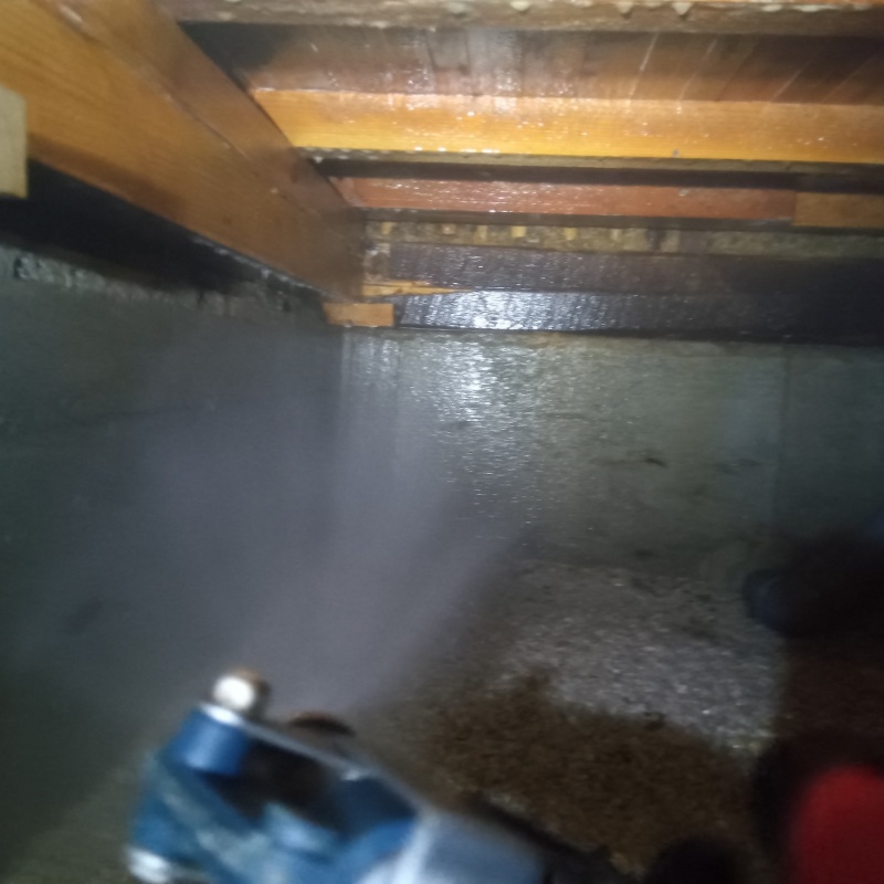 床下の基礎部分にシロアリ駆除剤を散布する様子