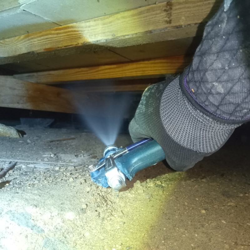 床下の木材にシロアリ駆除剤を散布する様子