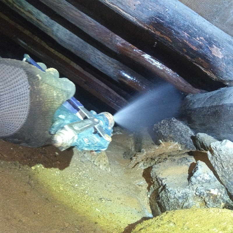 床下の木材にシロアリ駆除剤を散布する様子