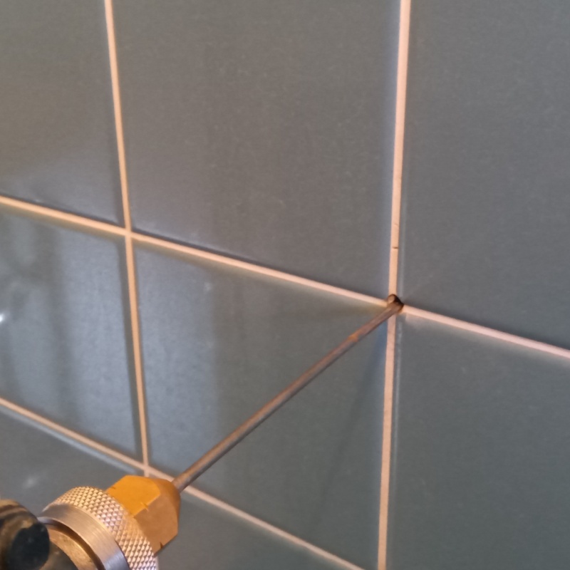 トイレ壁に穴を開けてシロアリ駆除剤を注入