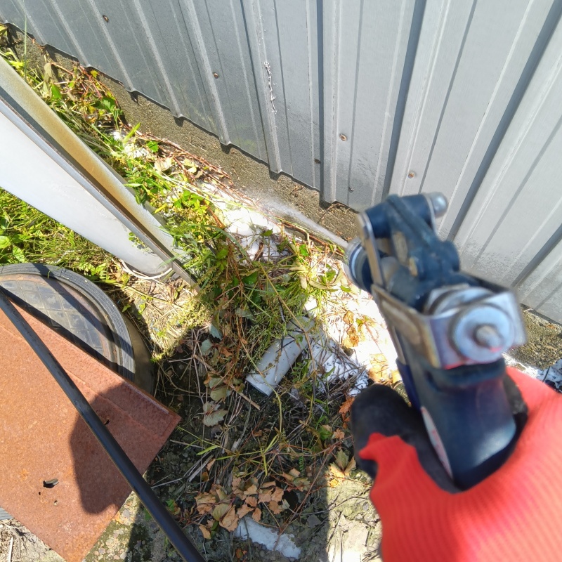 建物外周の土壌にシロアリ駆除剤を吹き付ける様子