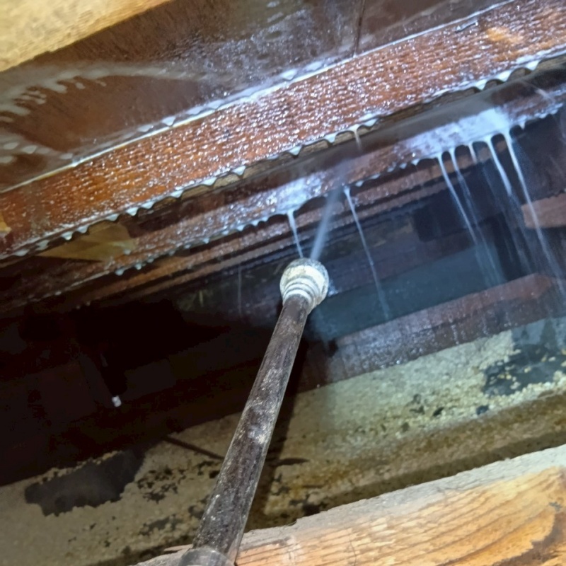 床下木材にシロアリ駆除剤を吹き付ける様子