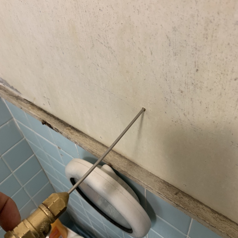 トイレ壁に穴を開けてシロアリ駆除剤を注入