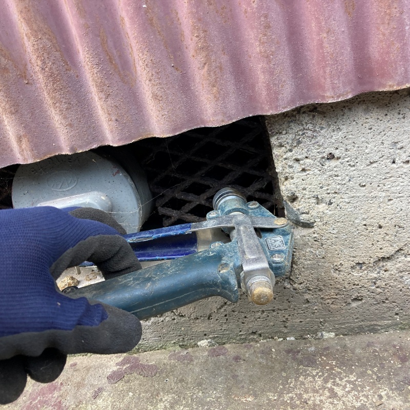 床下換気口まわりの地面にシロアリ駆除剤を散布