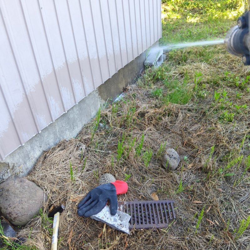 建物外周の土壌にシロアリ駆除剤を吹き付ける様子