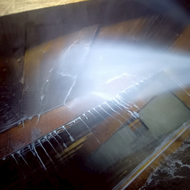 床下木材にシロアリ駆除剤を吹き付ける様子