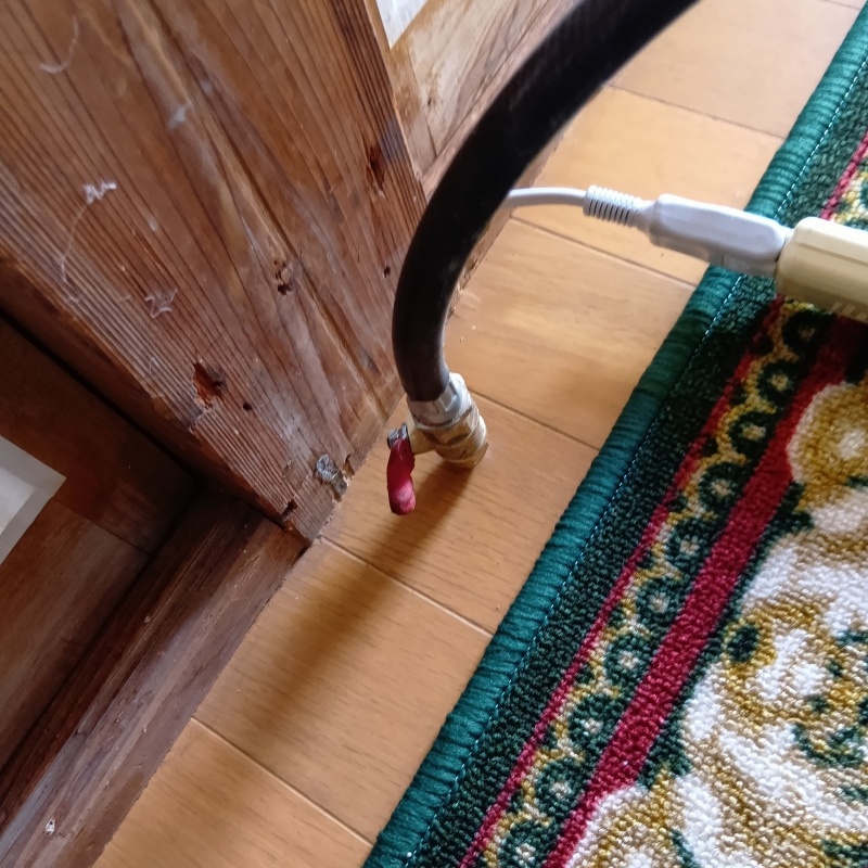 リビングの床にシロアリ駆除剤を注入する様子