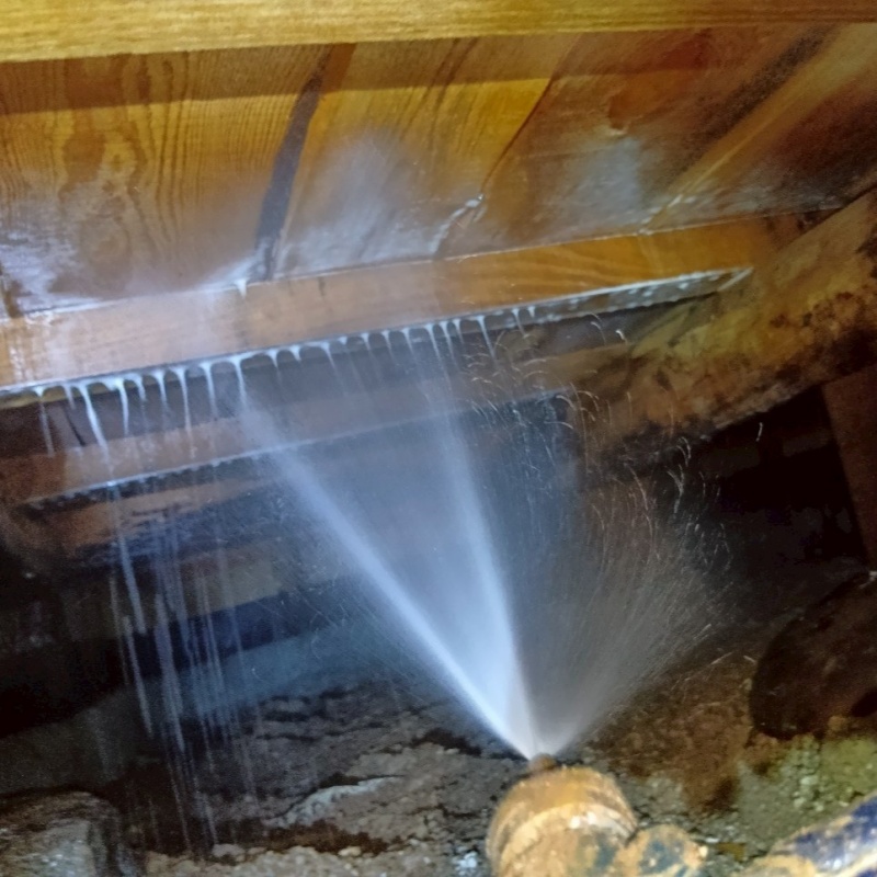 床下の木材にシロアリ駆除剤を散布する様子