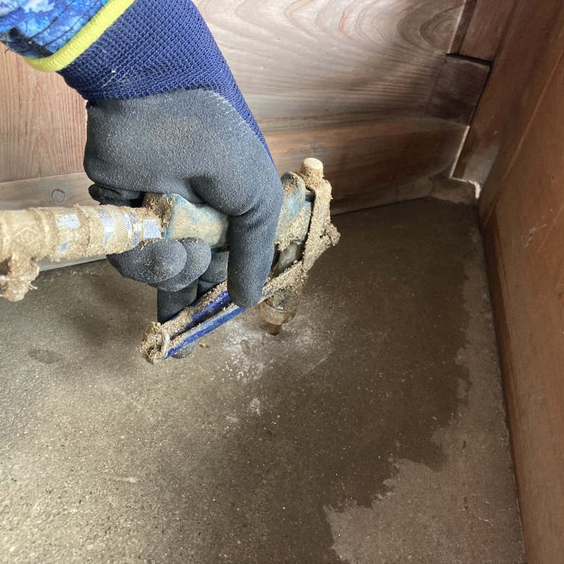 玄関の床にシロアリ駆除剤を注入する様子