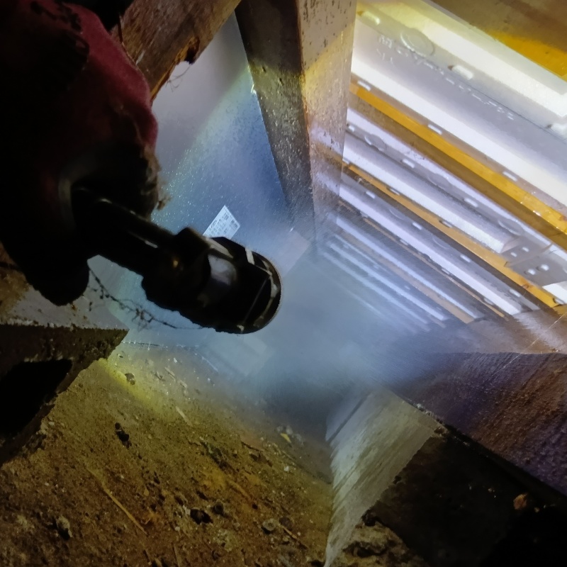 床下の土壌にシロアリ駆除剤を散布する様子