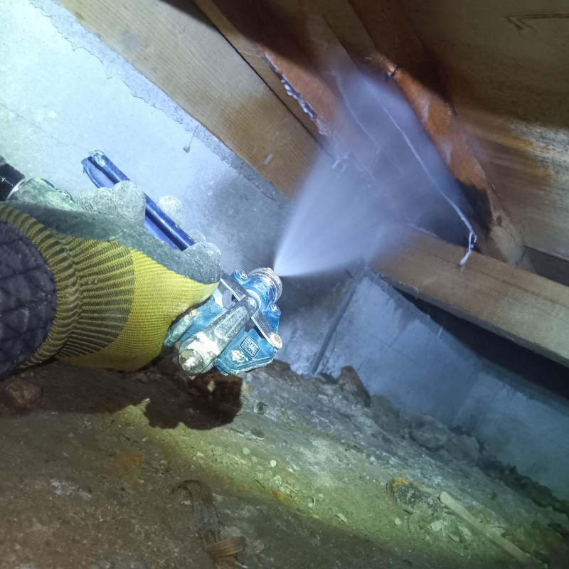 床下の木材にシロアリ駆除剤を散布する様子