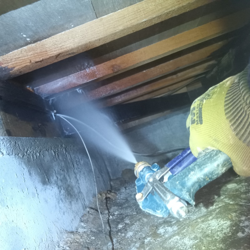 床下の木材にシロアリ駆除剤を散布する様子