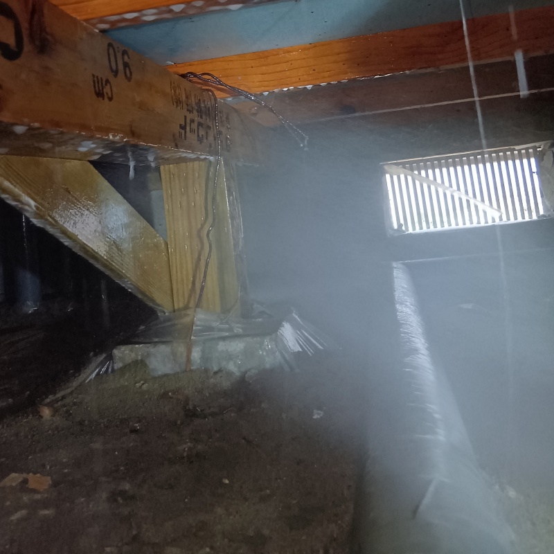 床下の土壌にシロアリ駆除剤を散布する様子