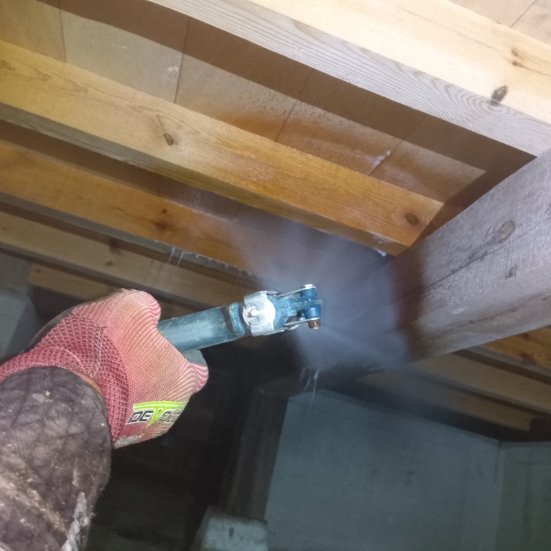 床下の木材にシロアリ駆除剤を散布する様子