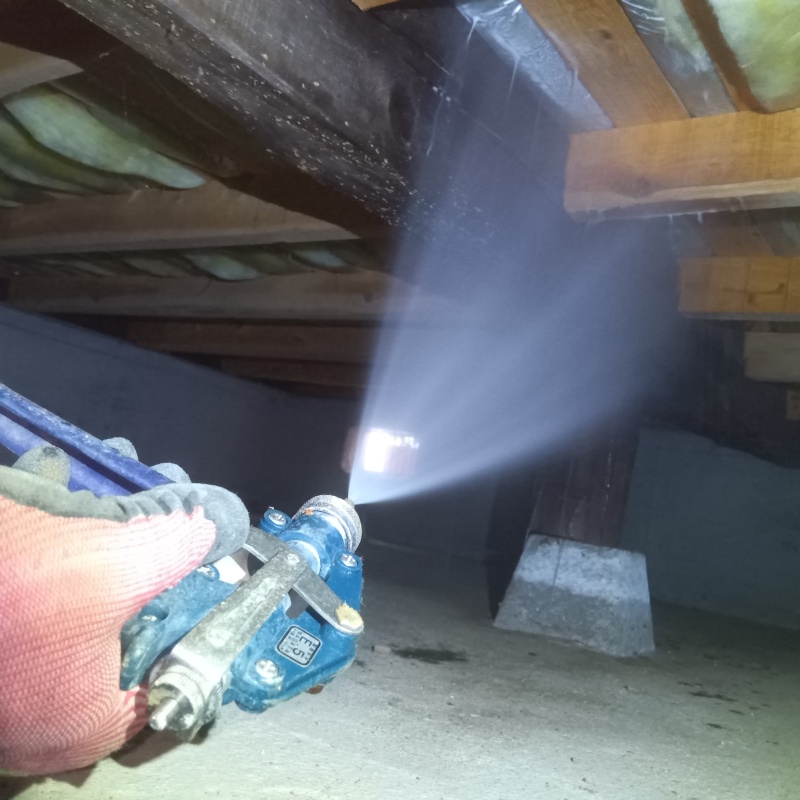 床下の木材にシロアリ駆除剤を散布する様子