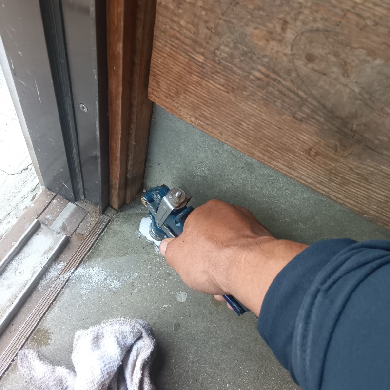 玄関の床に防蟻剤を注入する様子