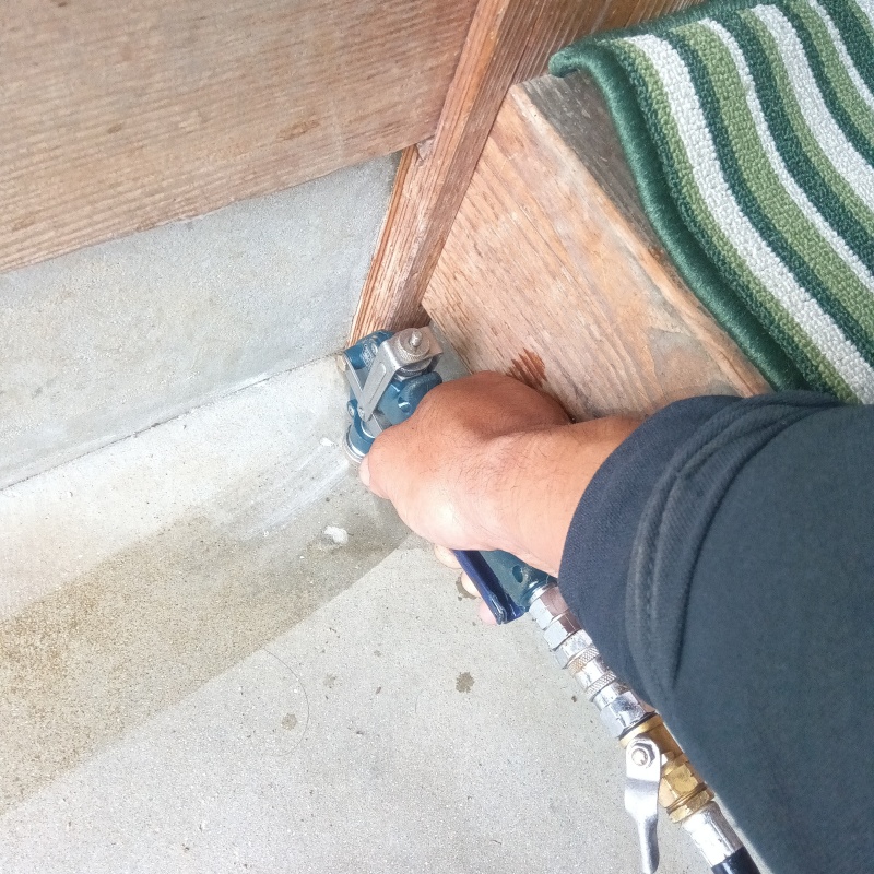 玄関の床に防蟻剤を注入する様子