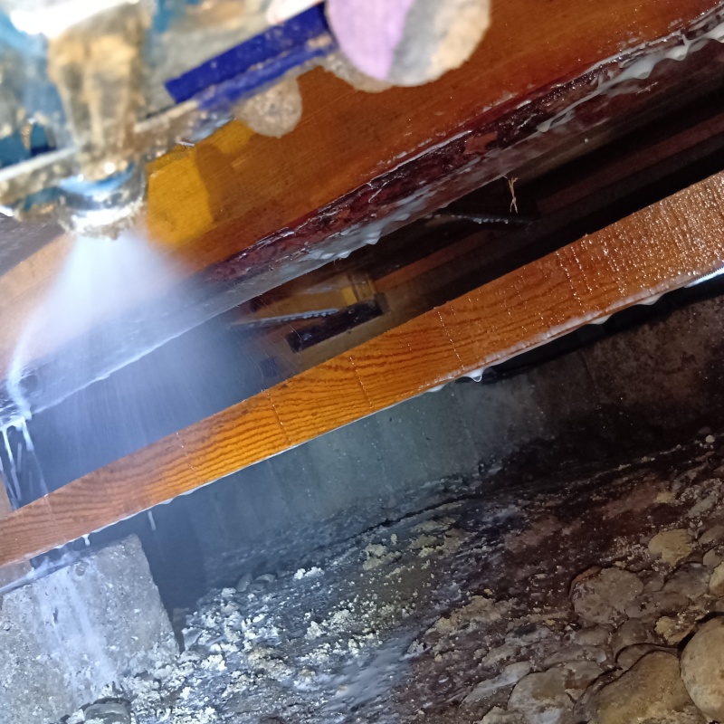 床下の木材にシロアリ駆除剤を散布する様子