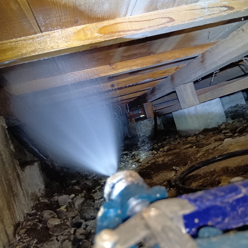 床下の木材にシロアリ駆除剤を散布する様子