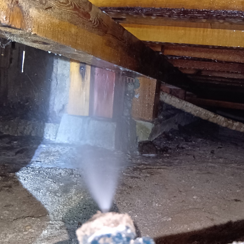 床下の基礎部分にシロアリ駆除剤を散布する様子