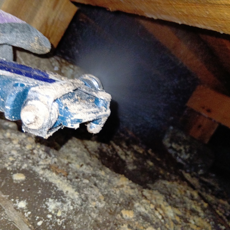 床下の土壌にシロアリ駆除剤を散布する様子