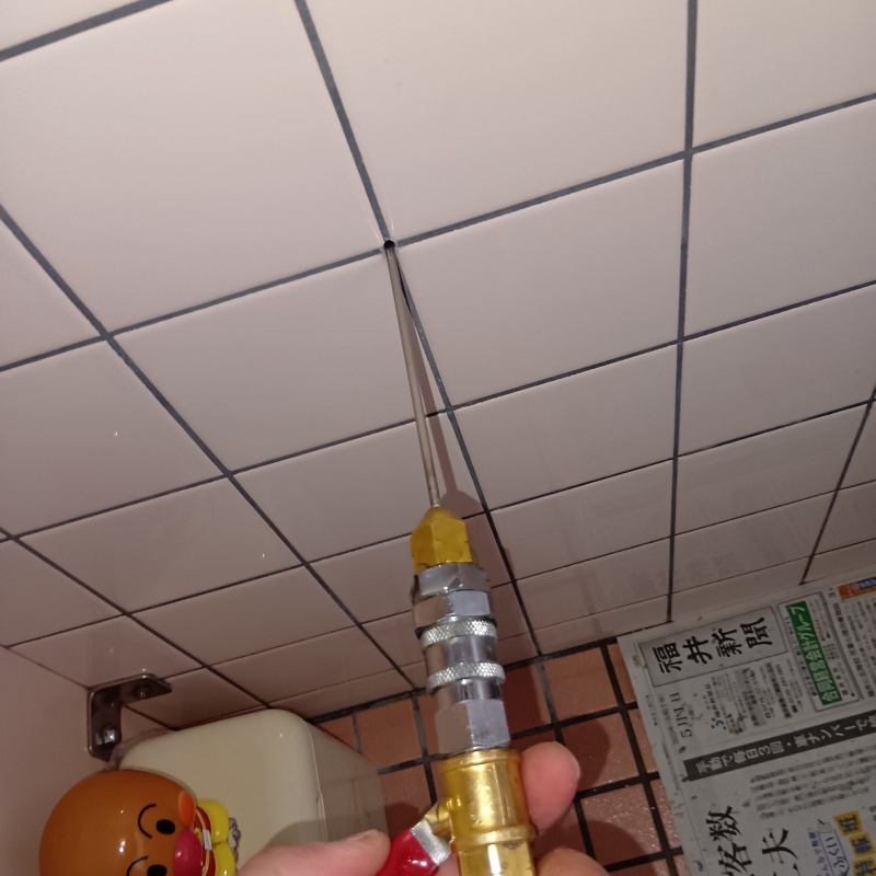 トイレの壁にシロアリ駆除剤を注入する様子