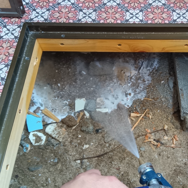床下の土壌にシロアリ駆除剤を散布する様子