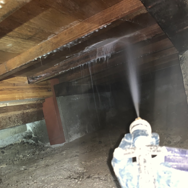 床下の木材にシロアリ駆除剤を散布する様子