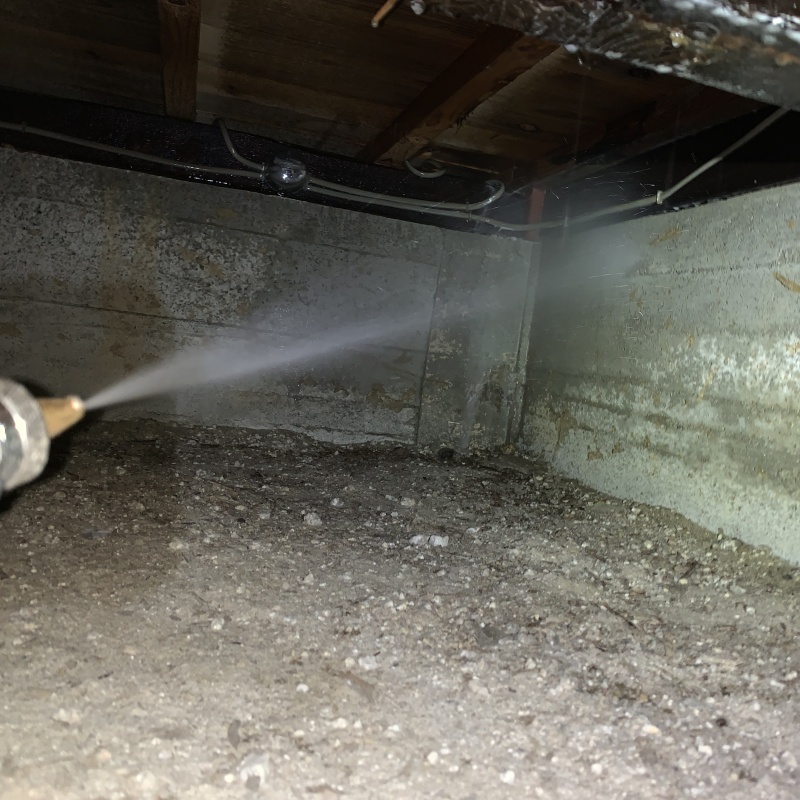 床下の基礎部分にシロアリ駆除剤を散布する様子