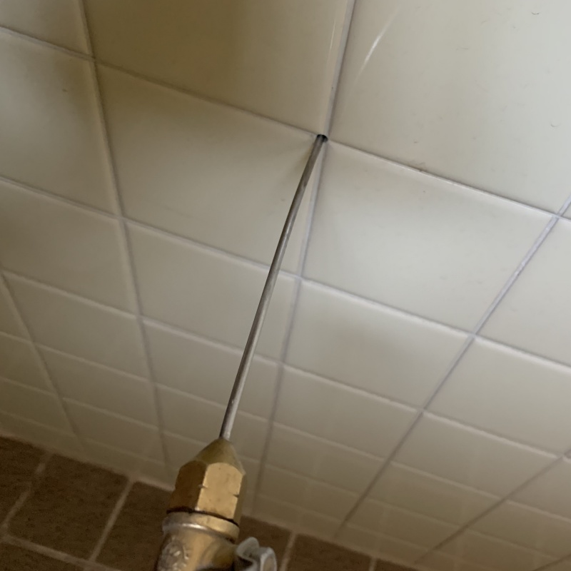 浴室の壁にシロアリ駆除剤を注入する様子