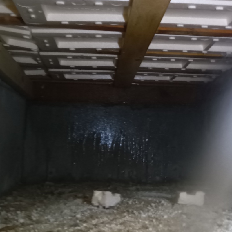 床下の基礎部分にシロアリ駆除剤を散布する様子