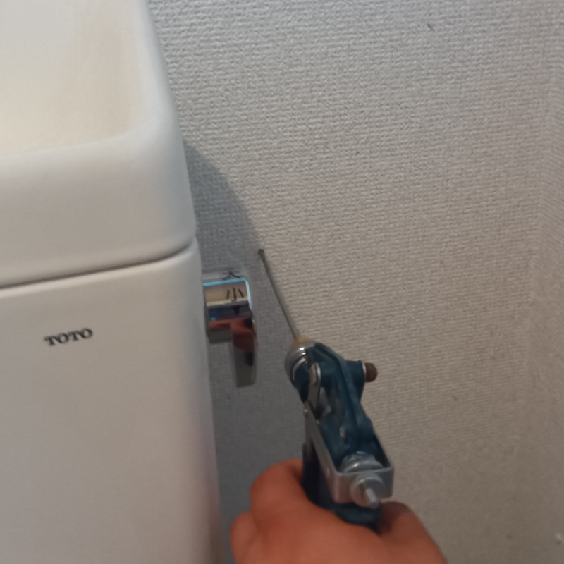 トイレの壁にシロアリ駆除剤を注入する様子