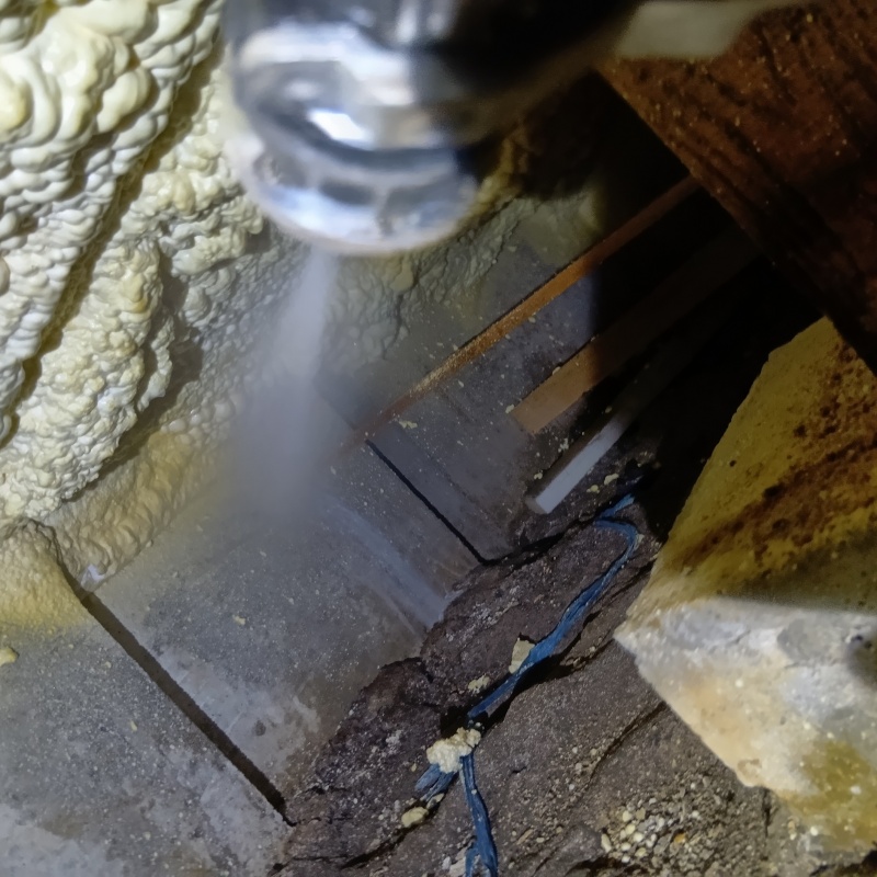 床下の基礎部分にシロアリ駆除剤を散布する様子