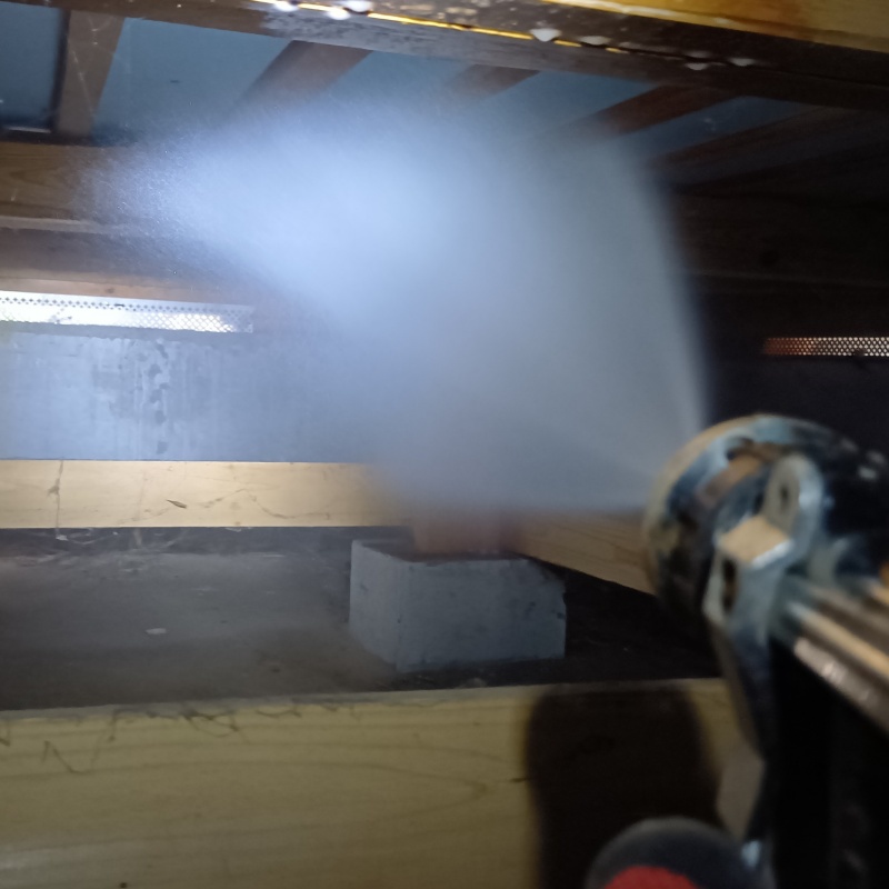 床下の木材にシロアリ駆除剤を散布する様子