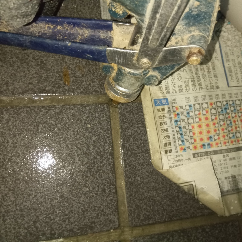 玄関の床にシロアリ駆除剤を注入する様子