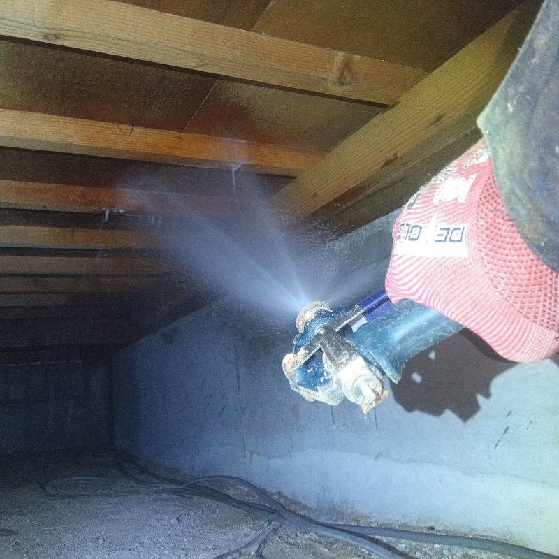 床下の木材にシロアリ駆除剤を散布する様子