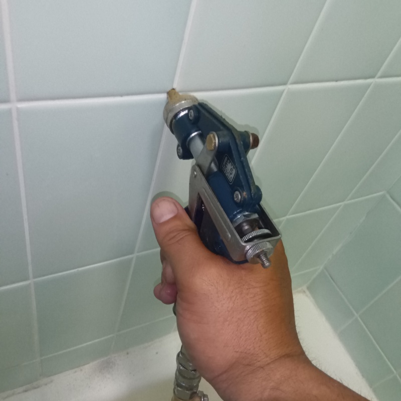 浴室の壁にシロアリ駆除剤を注入する様子