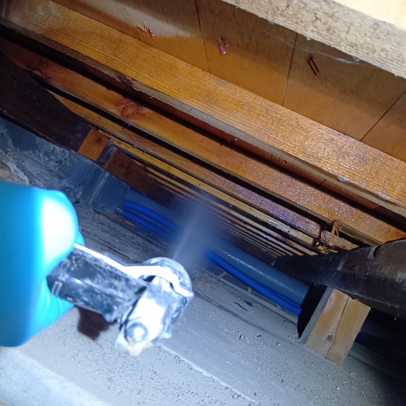 床下の木材にシロアリ駆除剤を散布する様子