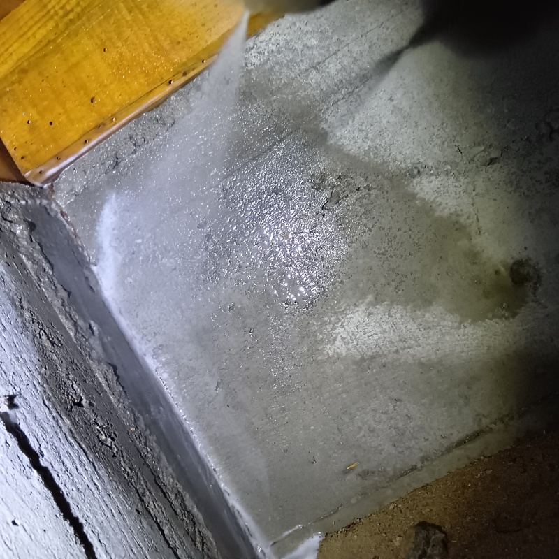 床下の基礎部分にシロアリ駆除剤を散布する様子