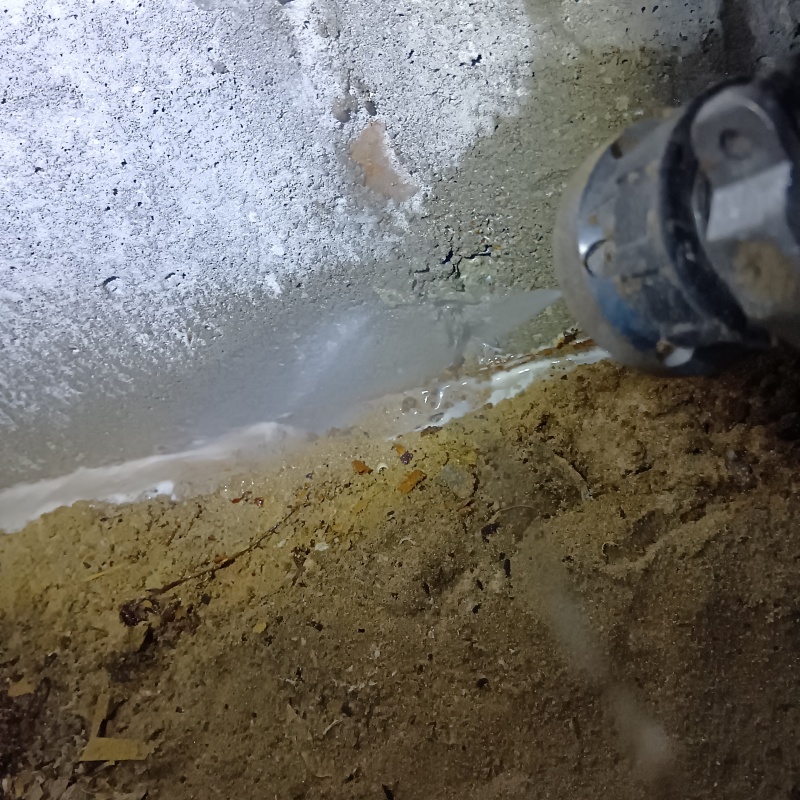 床下の基礎部分にシロアリ駆除剤を散布する様子