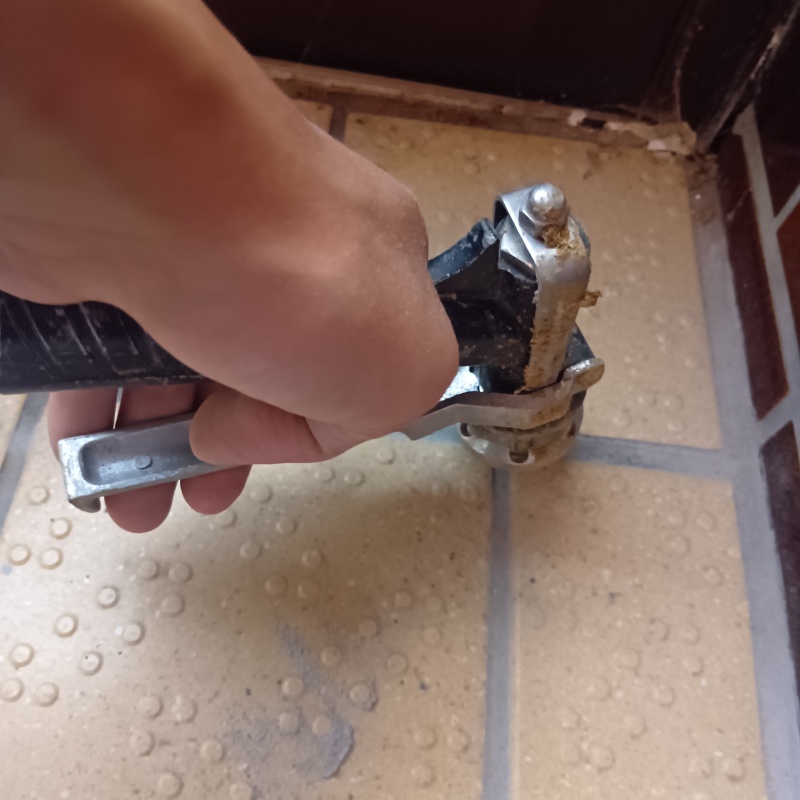 玄関の床にシロアリ駆除剤を注入する様子