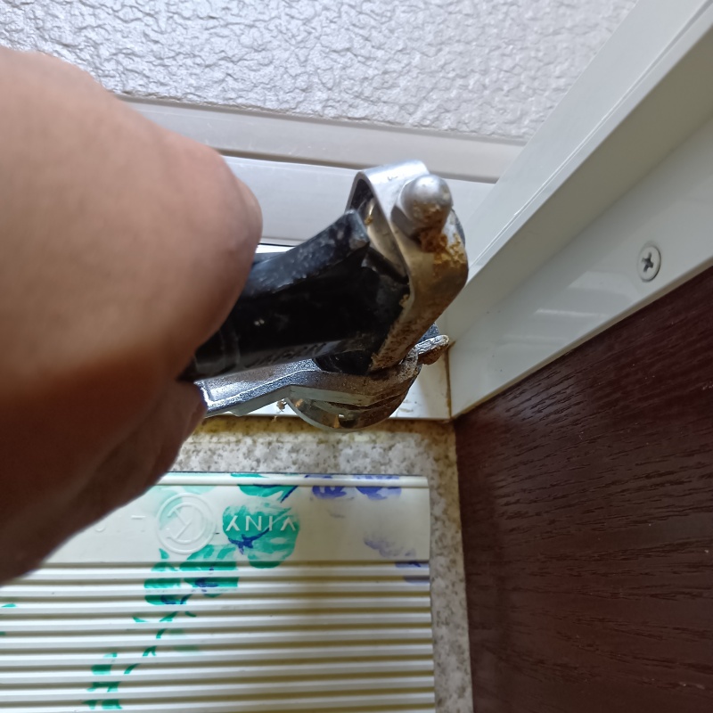 浴室のサッシ部分にシロアリ駆除剤を注入する様子