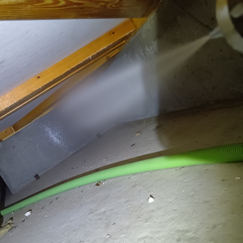 床下の基礎部分にシロアリ駆除剤を散布する様子