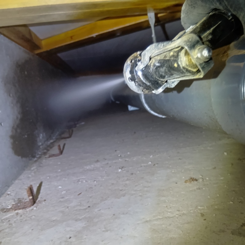 床下の基礎部分にシロアリ駆除剤を散布する様子