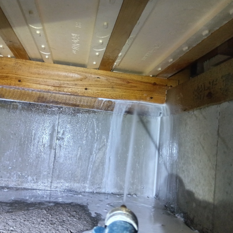 床下の木材にシロアリ駆除剤を散布する様子